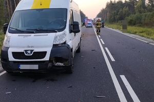 uszkodzone auto, w tle pracujące na miejscu służby