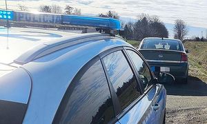 policjant kontroluje kierującą oplem