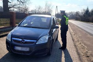 policjant wręcza ulotkę kierowcy