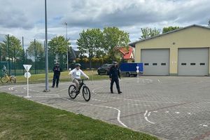 chłopiec jadący rowerem obok policjanci