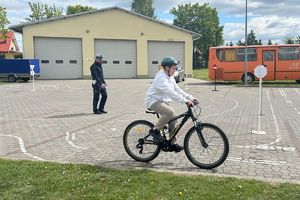 chłopiec jadący rowerem obok policjant