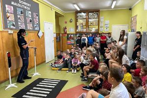 policjantka rozmawia z dziećmi w otoczeniu znaków drogowych