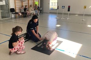 policjantka pokazuje dziewczynkom pozycję "żółwia"