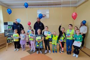 dzieci z elementami odblaskowymi z policjantami