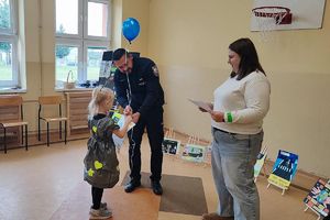policjant wręcza dziecku nagrodę