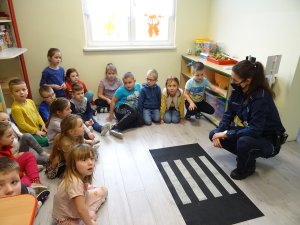 policjantka prowadzi zajęcia dla dzieci w sali przedszkolnej