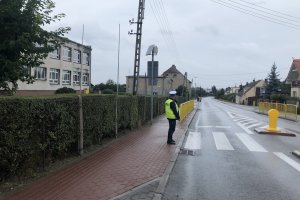 policjant kontroluje przejście dla pieszych w rejonie szkoły