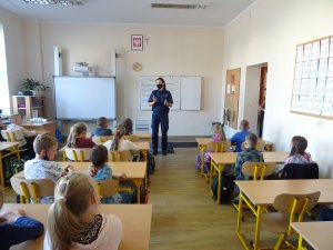 policjanta rozmawia w klasie z uczniami na temat bezpieczeństwa