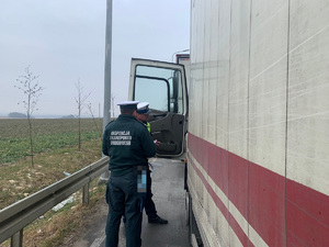 policjant i funkcjonariusz ITD kontrolują pojazd ciężarowy