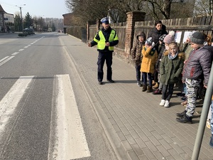 policjant tłumaczy zasady ruchu pieszych po przejściu
