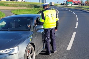 policjant sprawdza trzeźwość kierowcy urządzeniem pomiarowym