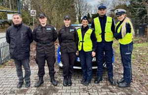 policjanci i uczniowie rozdają odblaski