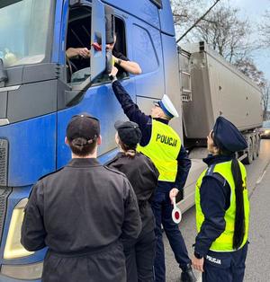 policjanci i uczniowie rozdają odblaski