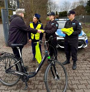 policjanci i uczniowie rozdają odblaski