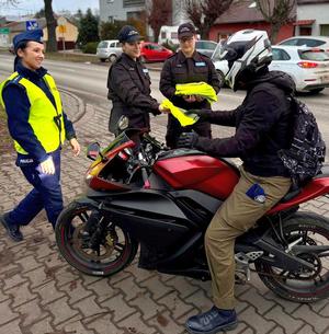 policjanci i uczniowie rozdają odblaski