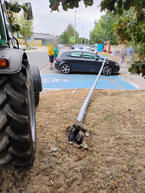 przewrócona latarnia leżąca na samochodzie