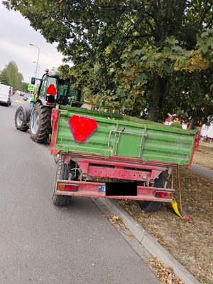 ciągnik stojący na jezdni i pasie zieleni