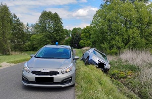 samochód w rowie, oraz nieoznakowany radiowóz policyjny ze światłem na dachu