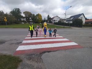 Policjantka ćwiczy przechodzenie przez przejście dla pieszych  z dziećmi ze Szkoły Podstawowej w Kamieniu Krajeńskim