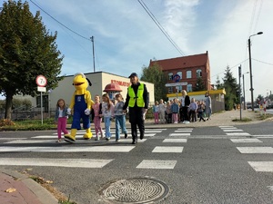 Policjantka przechodzi przez jezdnię razem z dziećmi