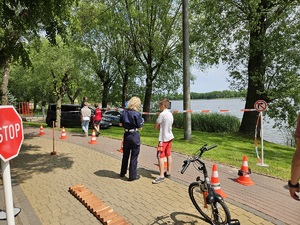 Policjantka z dzieckiem przy miasteczku ruchu drogowego