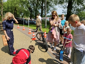 Policjantka z dzieckiem przy miasteczku ruchu drogowego