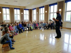 Policjant tłumaczy dzieciom zasady bezpieczeństwa
