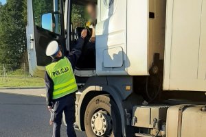 Funkcjonariusz sprawdza trzeźwość kierowcy samochodu ciężarowego