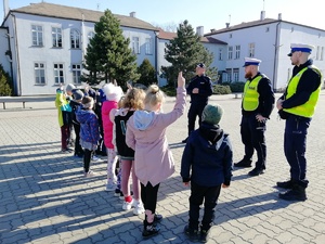 Dzieci zgłaszają się do odpowiedzi na pytania policjantów