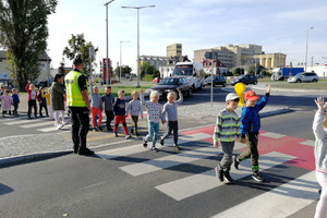 Policjant dba o bezpieczeństwo dzieci podczas przechodzenia przez jezdnię