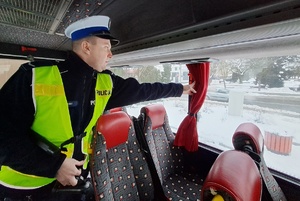 Policjant ruchu drogowego sprawdza wyposażenie autokaru