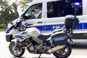 Motocykl marki Honda na tle policyjnego radiowozu