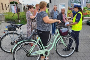 Kobiety z rowerami rozmawiają z policjantami na parkingu