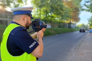 Policjant mierzy prędkość pojazdów w rejonie szkoły