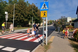 Dzieci w obecności policjanta przechodzą przez jezdnię