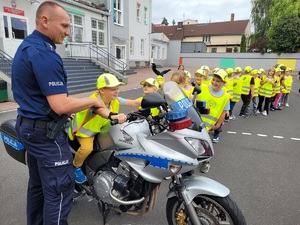 Policjant prezentuje policyjny motocykl dzieciom