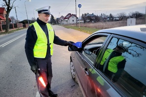 Policjanci ruchu drogowego podczas akcji rozdają kierowcom skrobaczki do szyb