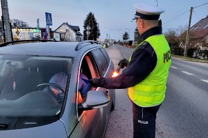Policjanci ruchu drogowego podczas akcji rozdają kierowcom skrobaczki do szyb