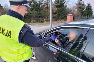 Policjanci ruchu drogowego podczas akcji rozdają kierowcom skrobaczki do szyb