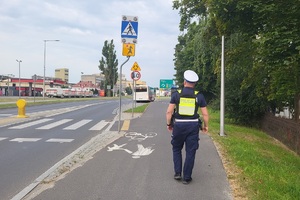 Policjant kontroluje oznakowanie przy placówkach oświatowych