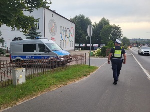 Policjant kontroluje oznakowanie przy placówkach oświatowych