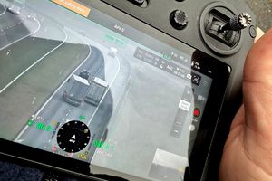 Policjant kontrolujący kierowcę ciężarówki i obserwujący ruch pojazdów dronem