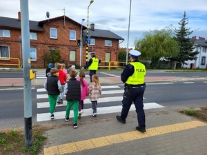 policjanci edukują dzieci przy przejściu dla pieszych