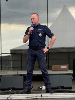 na zdjęciach policjant przemawiający ze sceny